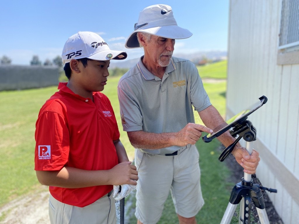 Coach reviewing swing video with a student