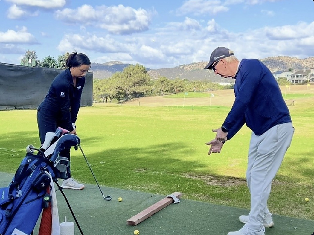 Coach working with a student on the lesson tee